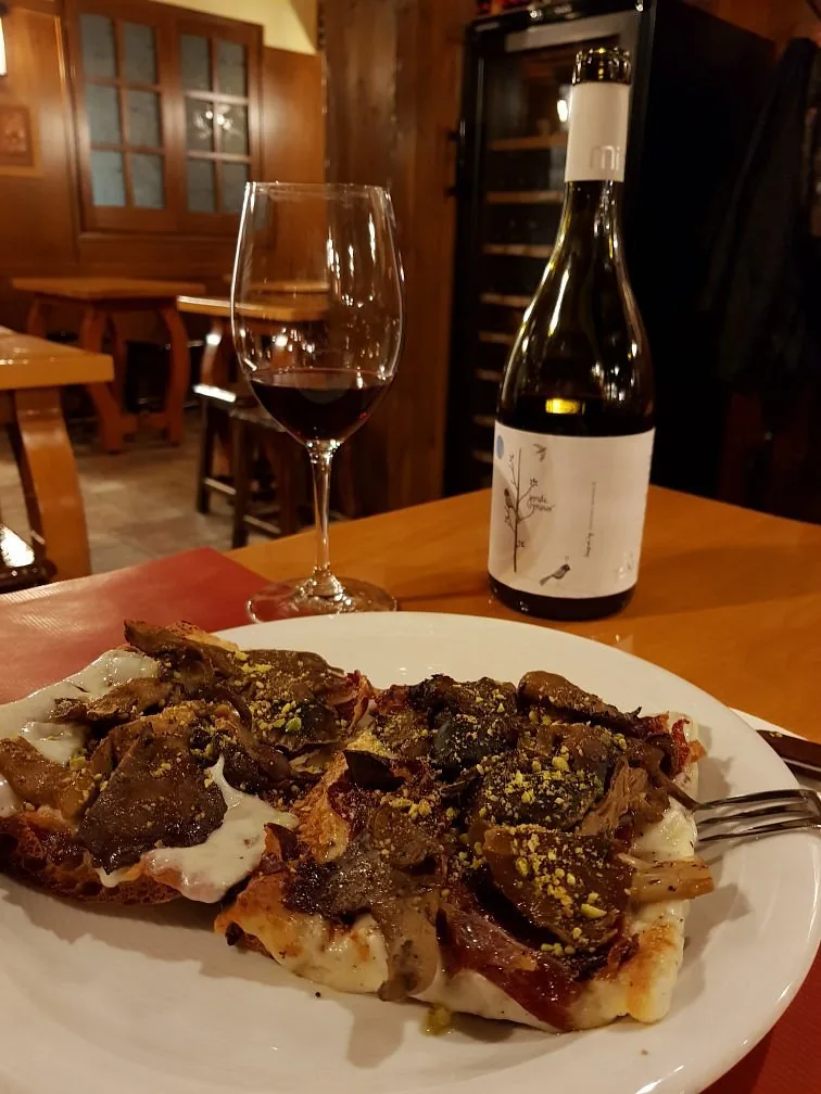 Copa de vino tinto junto a una coca en el comedor